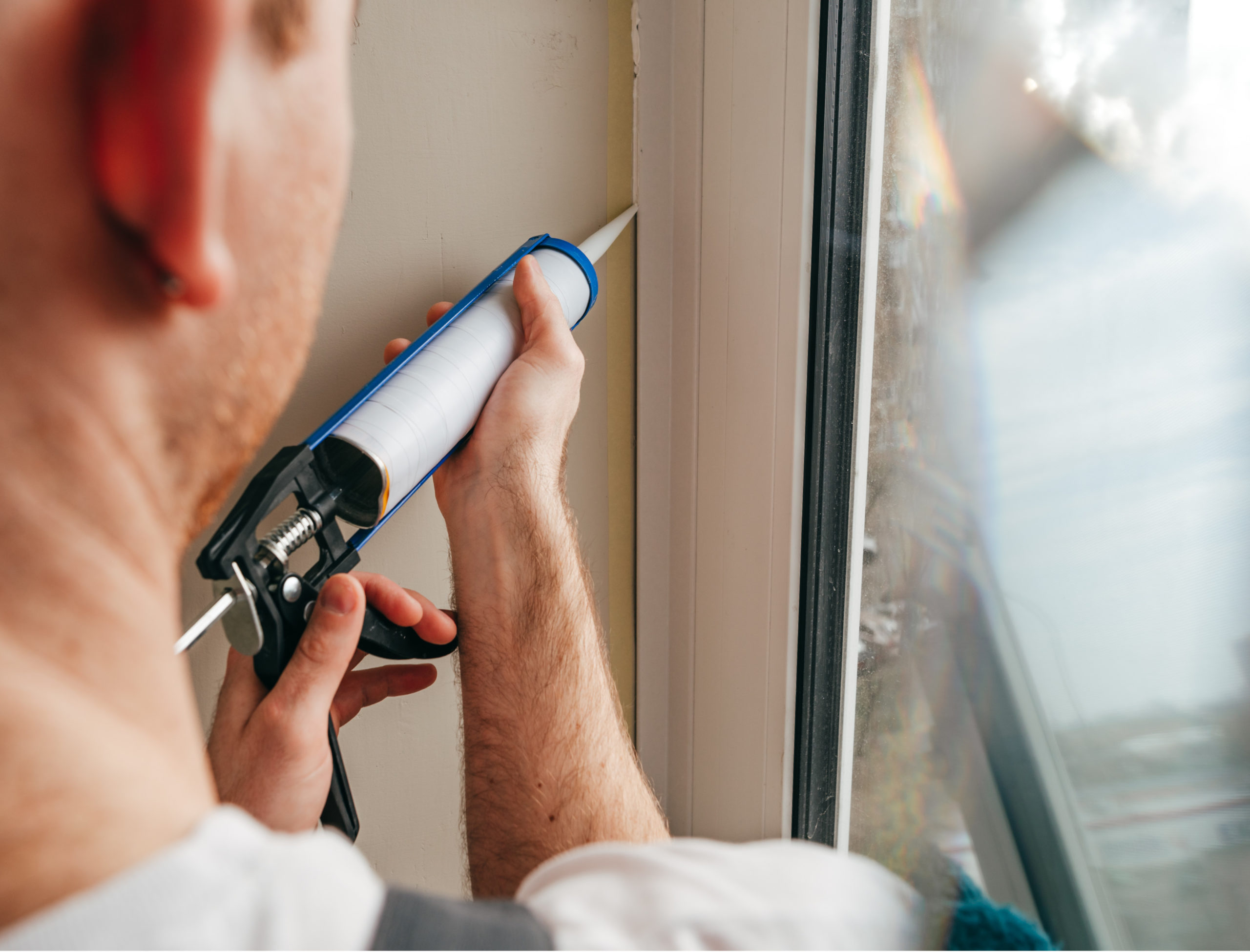 man installing caulking