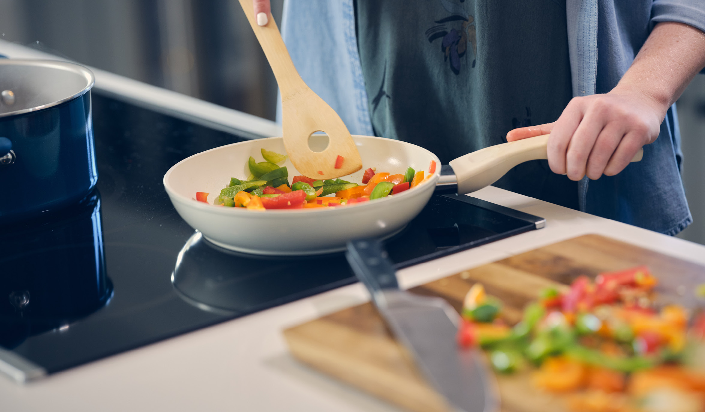 woman cooking on induction cooktop