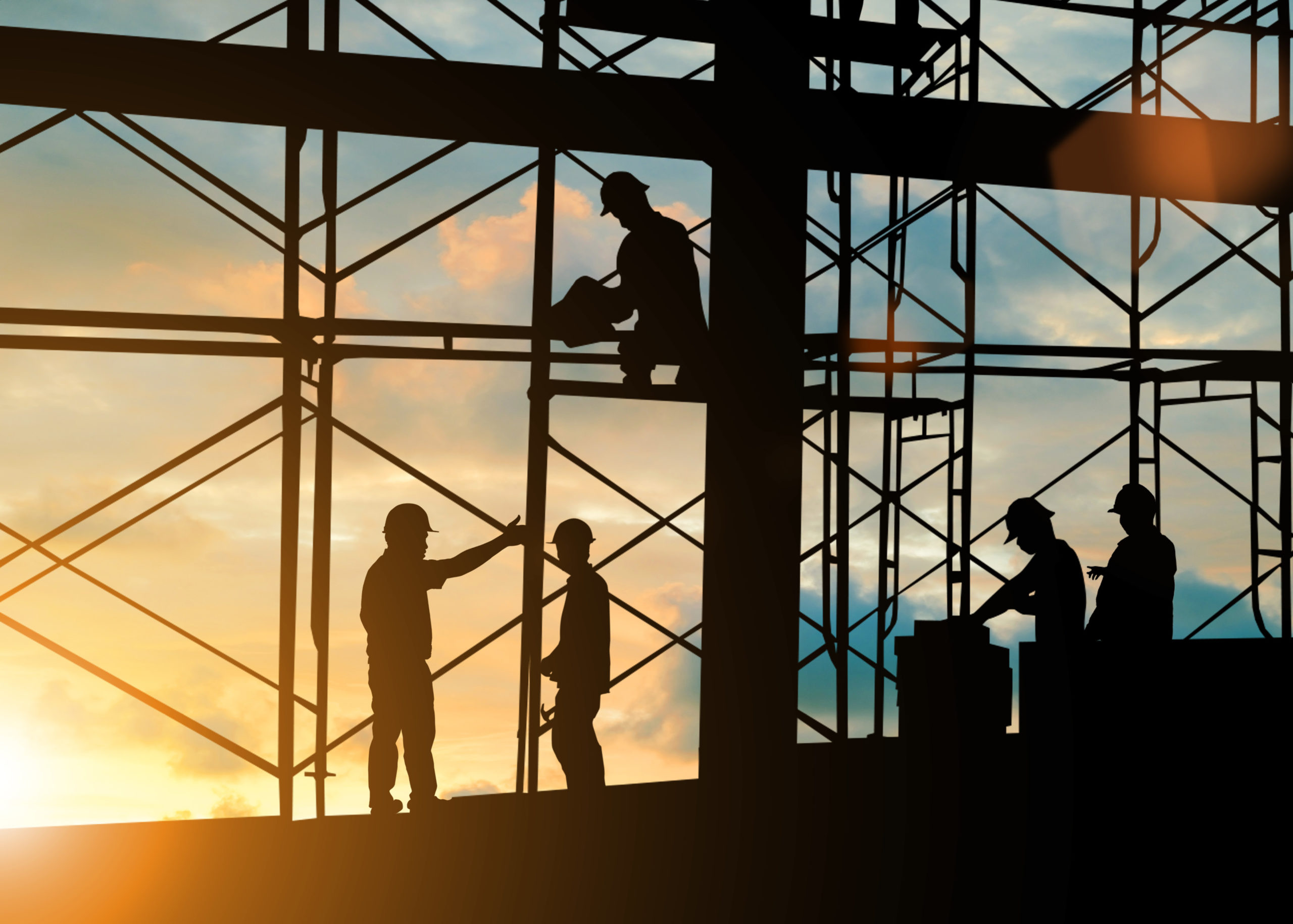 workers silhouetted at construction site