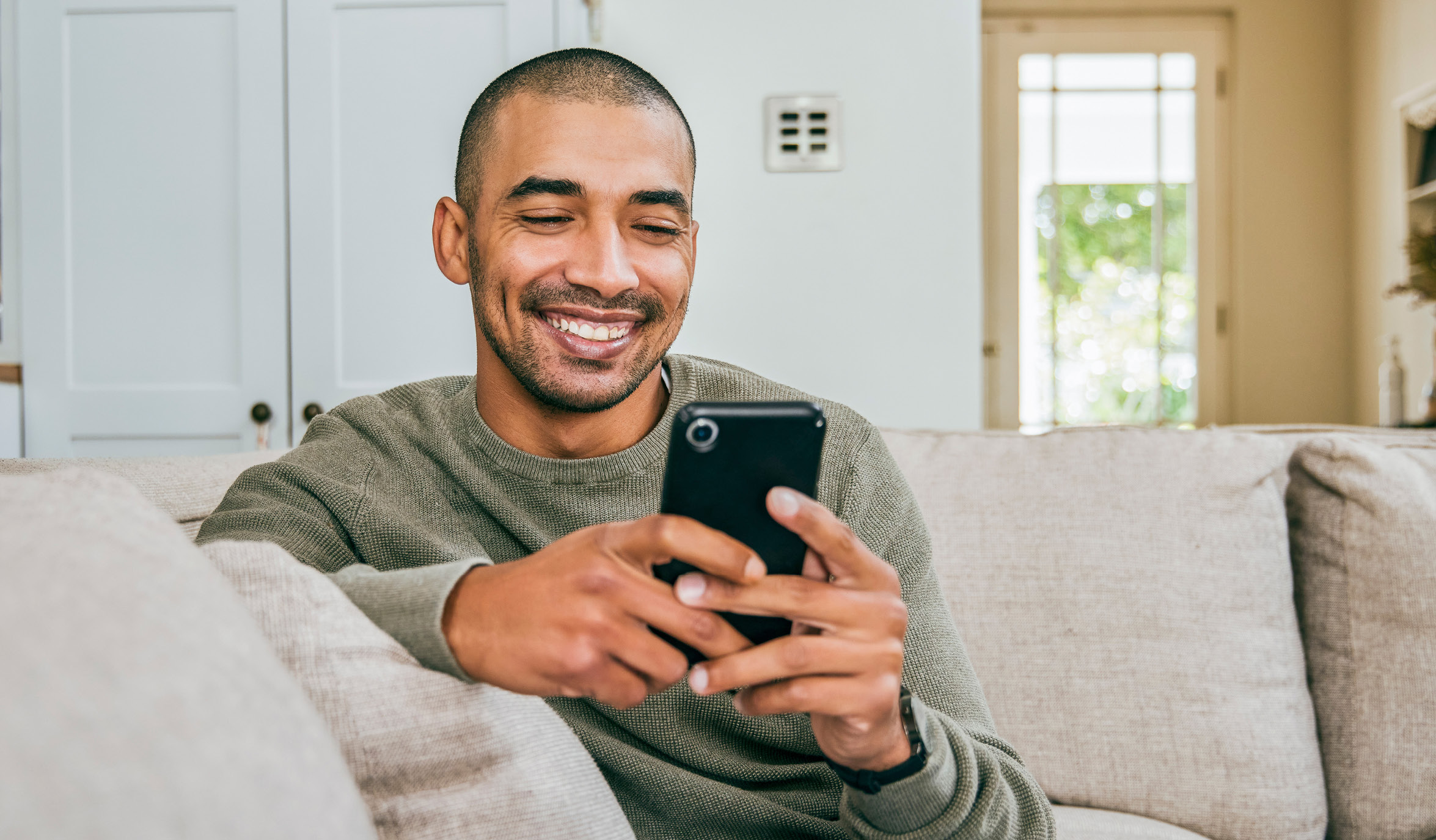 Man on couch using phone