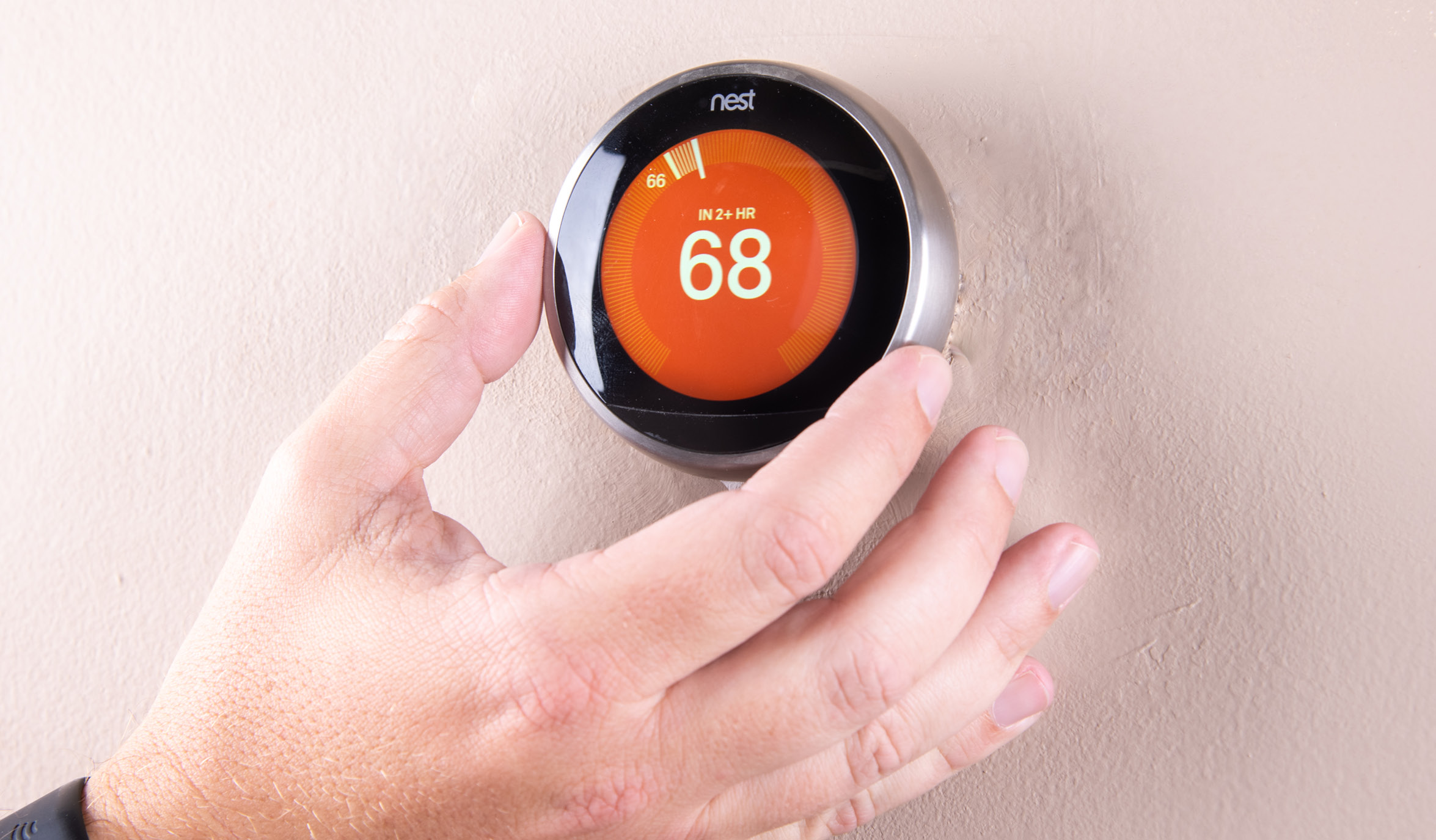 man adjusting smart thermostat