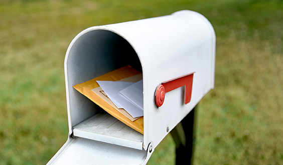 white mailbox open with mail inside