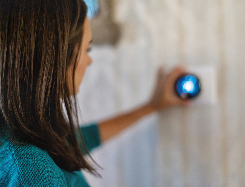 Woman turning down thermostat