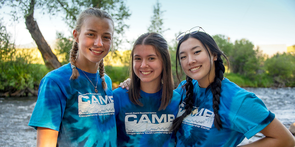 Three youth campers with river in background