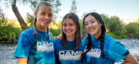 Three youth campers with river in background