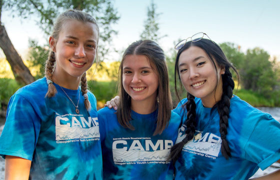 Three youth campers with river in background