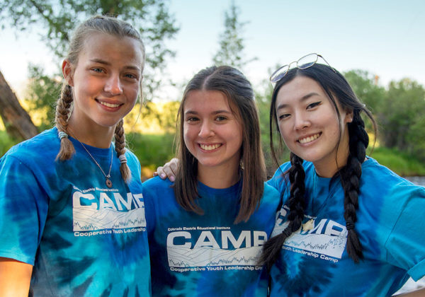 Three youth campers with river in background