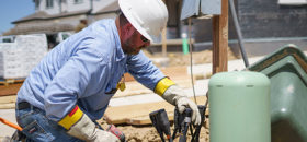 Lineman hooking up lines at a new house