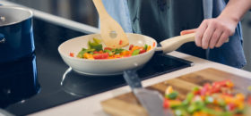 woman cooking on induction cooktop