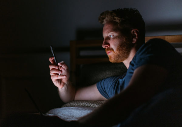 man in dark on phone