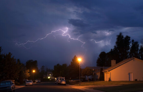 lighting strikes in clouds above neighborhood