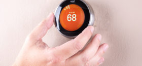 man adjusting smart thermostat