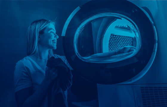 Woman Putting Clothing Into Dryer