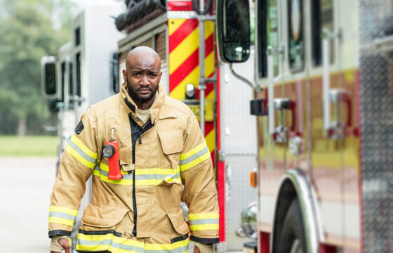 Fireman Walking Next To Firetruck while it Rains